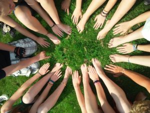 Picture of hands and feet of a group of people on grass 